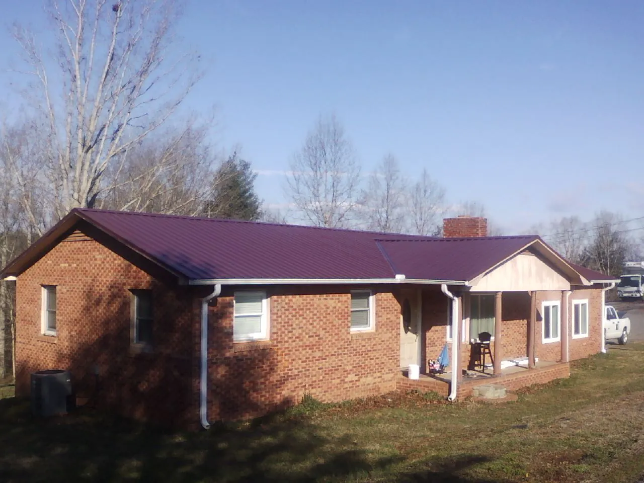 Burgundy metal roof on a brick ranch home with a new addition in Jewell